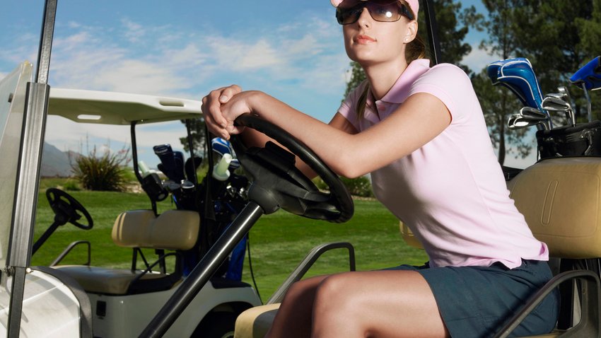 Junge Frau sitzt in einem Golf Cart