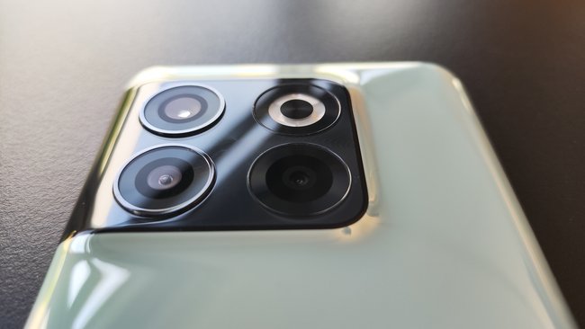 Pokazano tył OnePlusa 10T, na którym zainstalowano potrójny aparat.  Na tym telefonie komórkowym nie ma napisu Hasselblad z powodu braku współpracy.