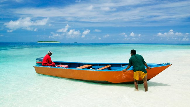 Funafuti-Atoll, Tuvalu: Zwei Männer und ein Fischerboot am Strand. Dieses Gebiet ist niedrig gelegen und dem Anstieg des Meeresspiegels ausgeliefert (Bildquelle: IMAGO / Nature Picture Library)
