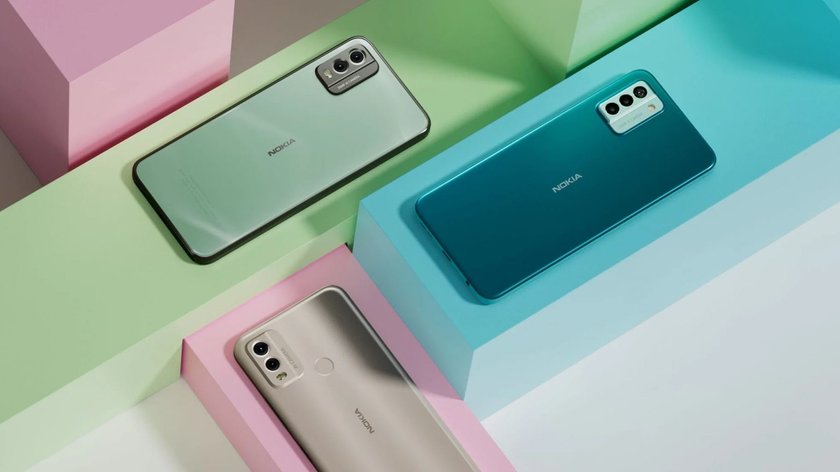 Auf einem weißen Tischen liegen 3 Smartphones von Nokia in silber, grün und blau. Beim blauen Modell handelt es sich um das neue G22.