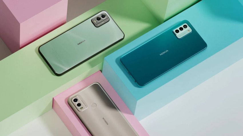 Auf einem weißen Tischen liegen 3 Smartphones von Nokia in silber, grün und blau. Beim blauen Modell handelt es sich um das neue G22.