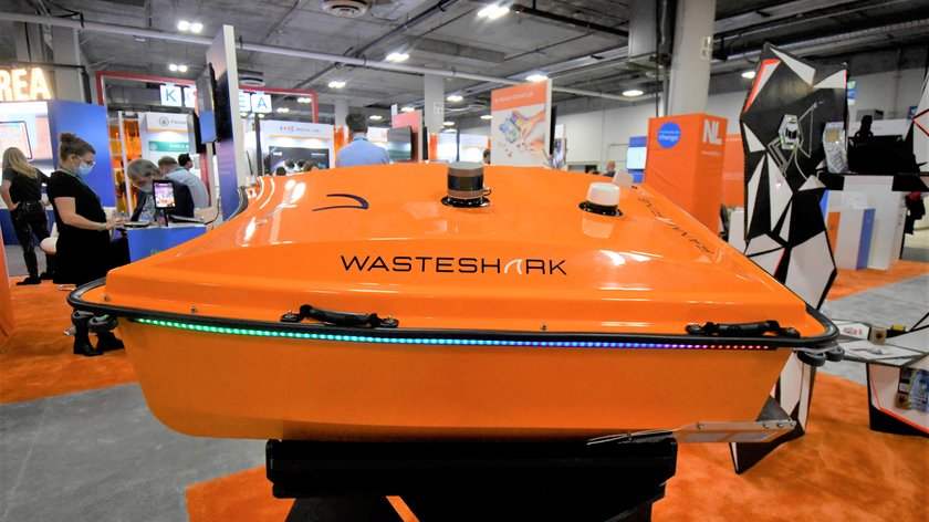 Auf einer Messe steht der orange Roboter Wasteshark.