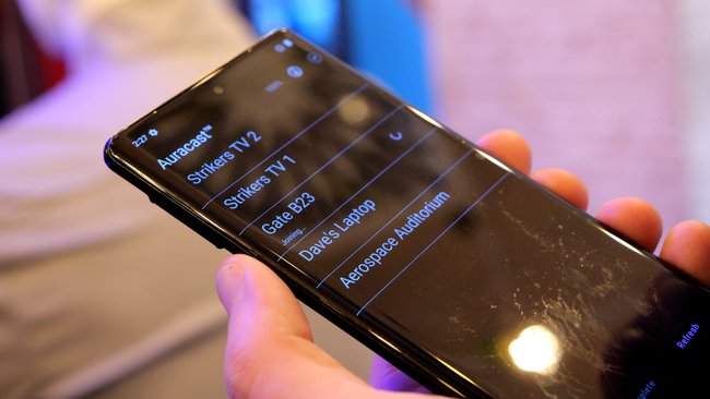 Auf einem Handy wird eine Liste an Auracast-Kanälen dargestellt.