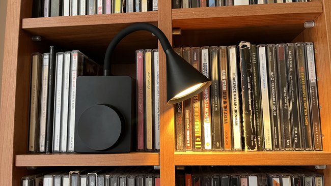 LED lamp Ikea Tågvirke in front of a CD shelf.
