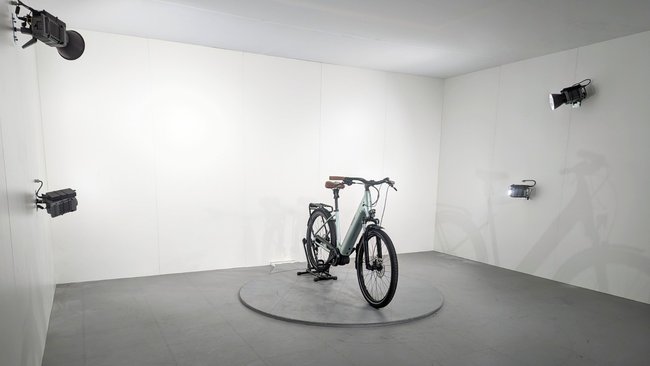 In einem Fotostudio steht ein E-Bike in der Mitte auf einem Podest.