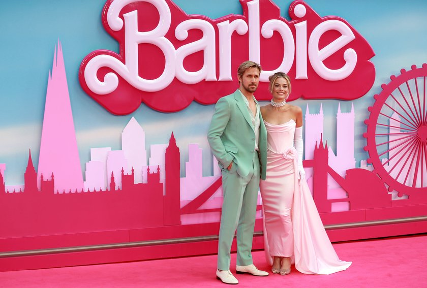 Vor einem Barbie-Banner auf dem roten Teppich stehen Margot Robbie und Ryan Gosling.