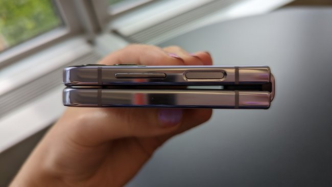 Eine Hand hält ein zugeklapptes Samsung Galaxy Z Flip 4 – im Hintergrund steht ein Tisch neben einem Fenster.
