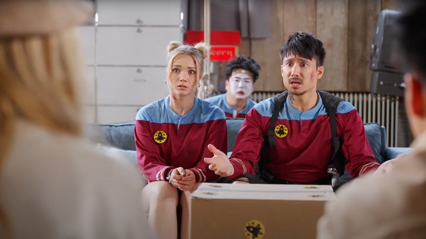 Julien bam und Julia Beautx sitzen nebeneinander in Space-Kostümen. Vor ihnen liegt ein Paket.