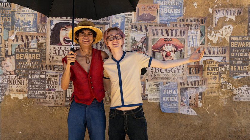 Ruffy und Corby stehen vor der Wand mit Wanted-Postern in der One Piece Realverfilmung