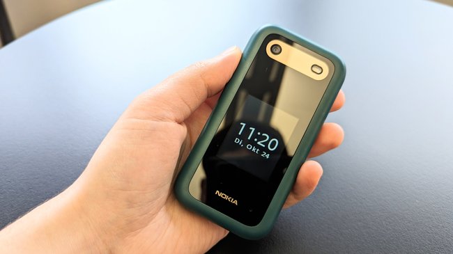 Das grüne Klapphandy Hãng Nokia 2660 Flip liegt in einer Hand.