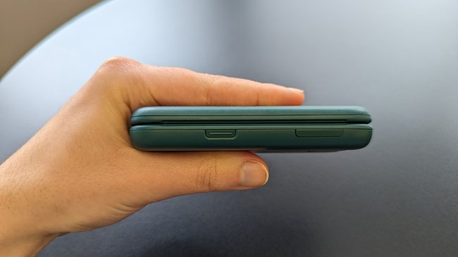 Das zugeklappte Hãng Nokia 2660 Flip wird in einer Hand gehalten. an der Seite gibt es eine Notfalltaste.