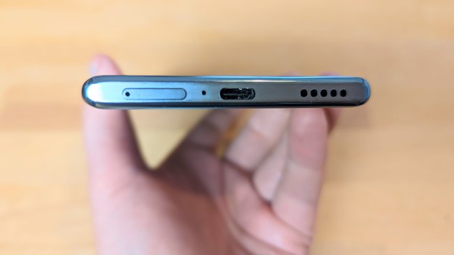 Eine Hand hält das Smartphone Honor 70 mit der Unterseite in die Kamera, sodass die Anschlüsse erkennbar sind.