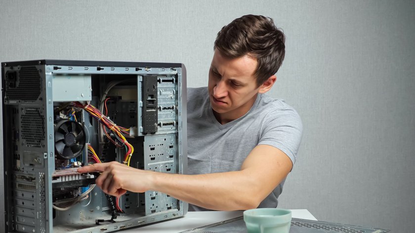 Young man opens a very dusty computer. Model Released Property Released xkwx computer, servic