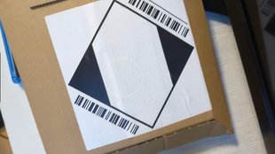 Amazon: Weißes Viereck mit schwarzen Dreiecken auf Paket – was bedeutet der Aufkleber?